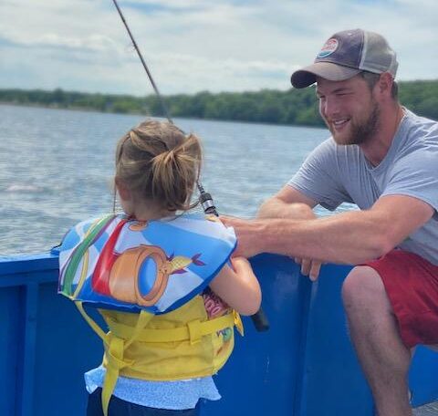 father and kid fishing on a launch boat